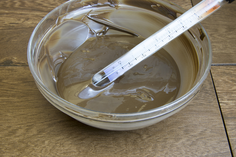 Candy thermometer in bowl of tempered chocolate